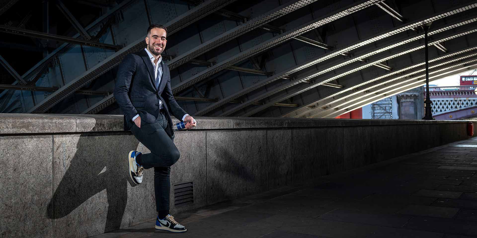Pedro Coelho onder brug tegen railing leunend