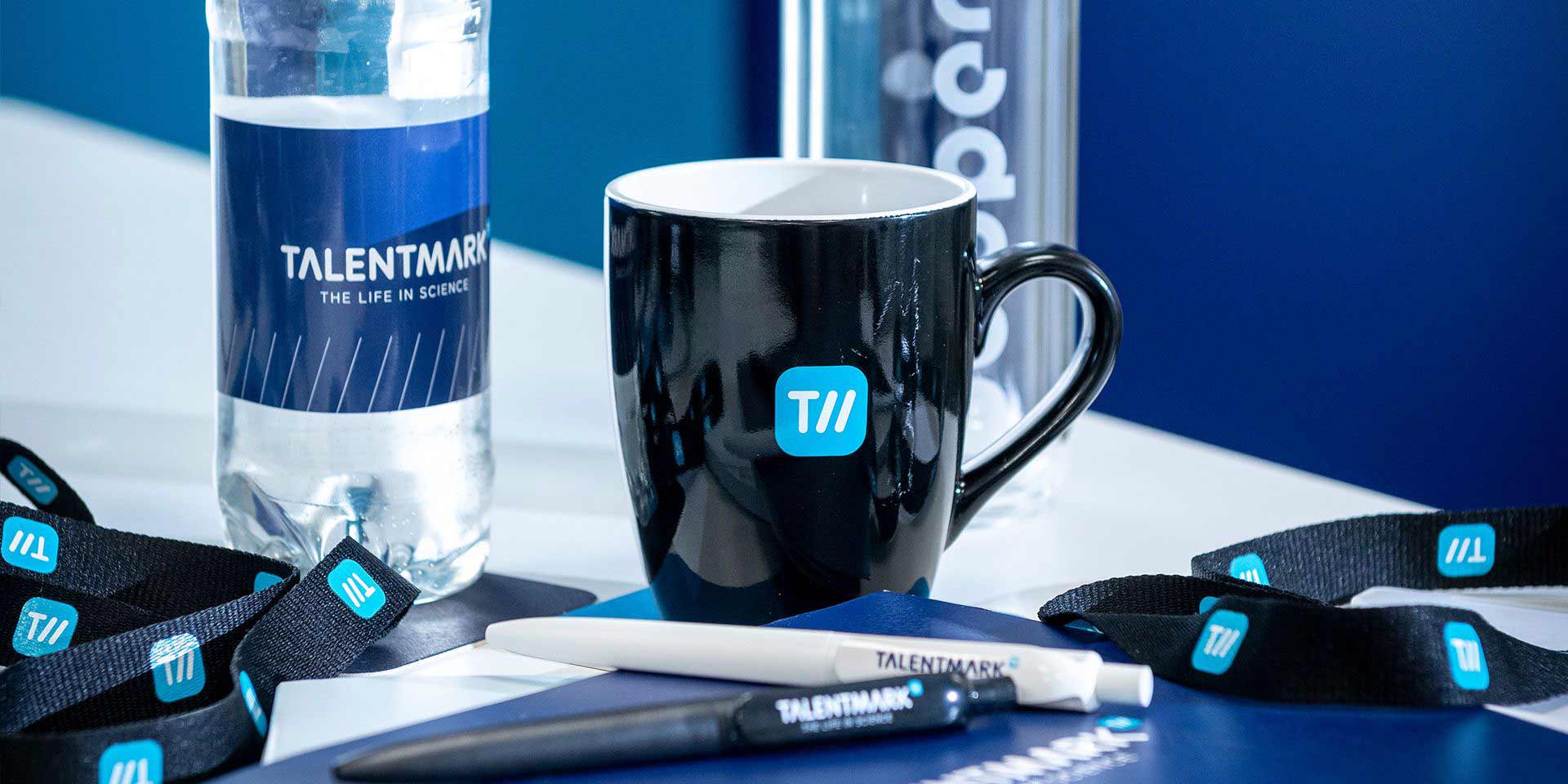 Keycord, waterfles, koffiekop en twee pennen van Talentmark