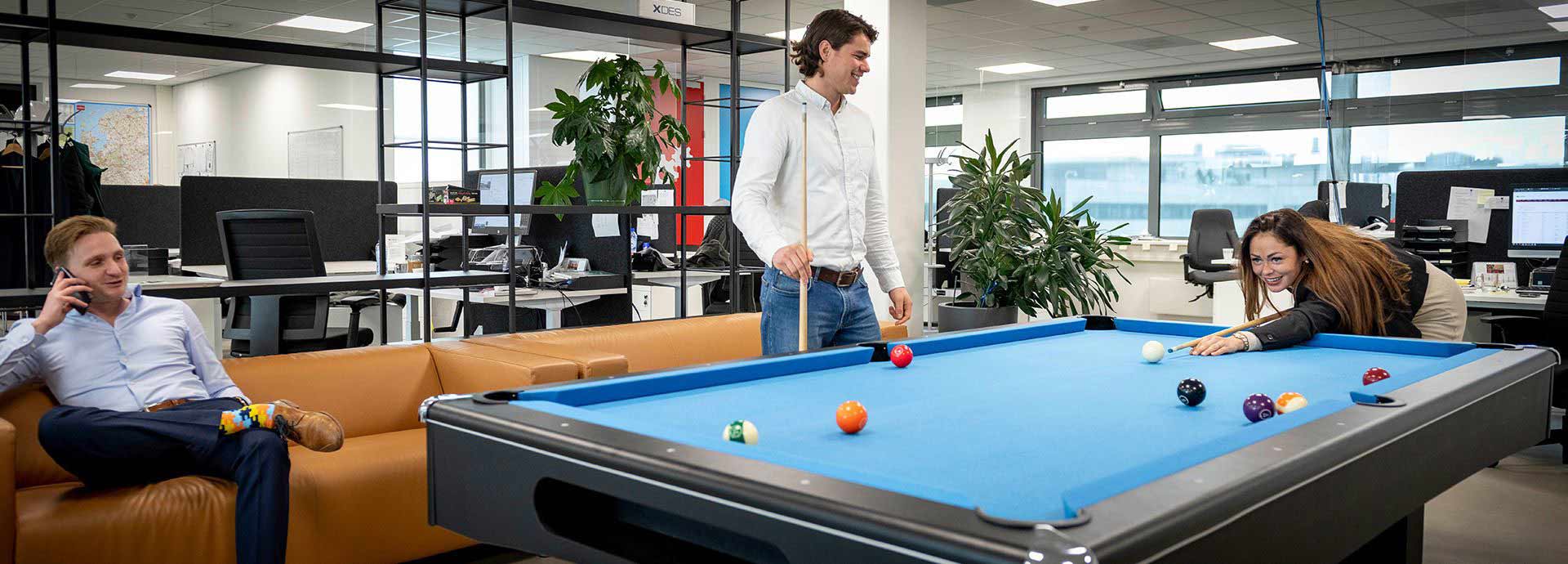 Three employees around pool table