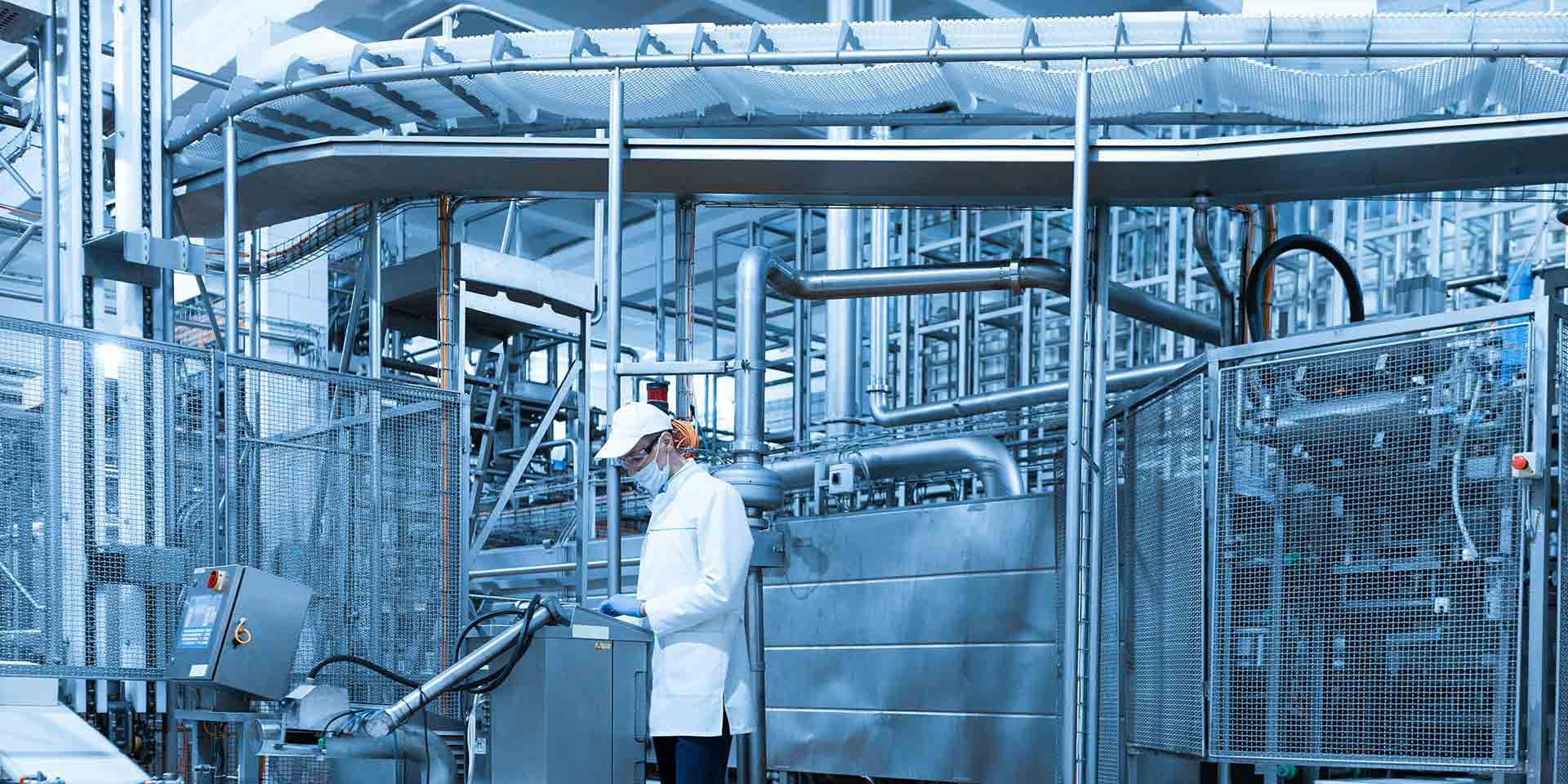 Laboratory with employee in white coat behind control panel