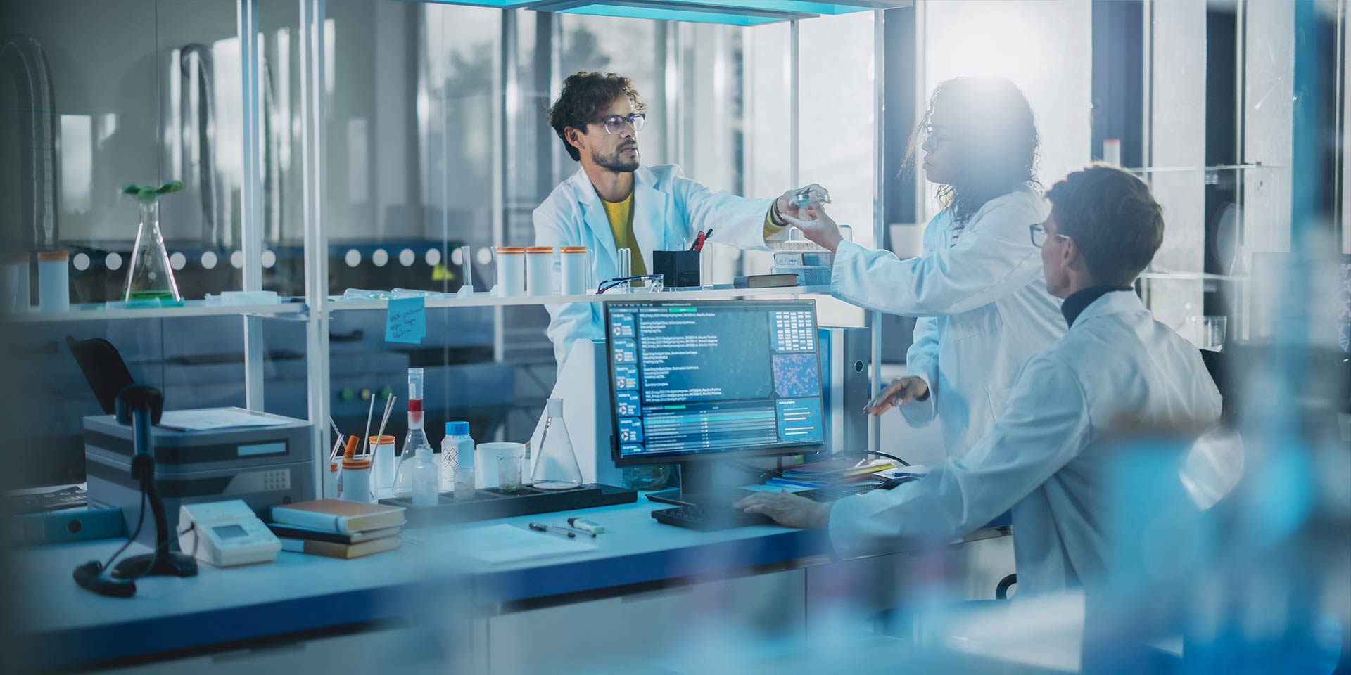 Lab with PC and three employees in white jackets